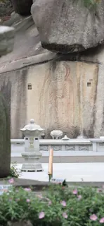 Una parete di granito scolpita, con lanterne di pietra